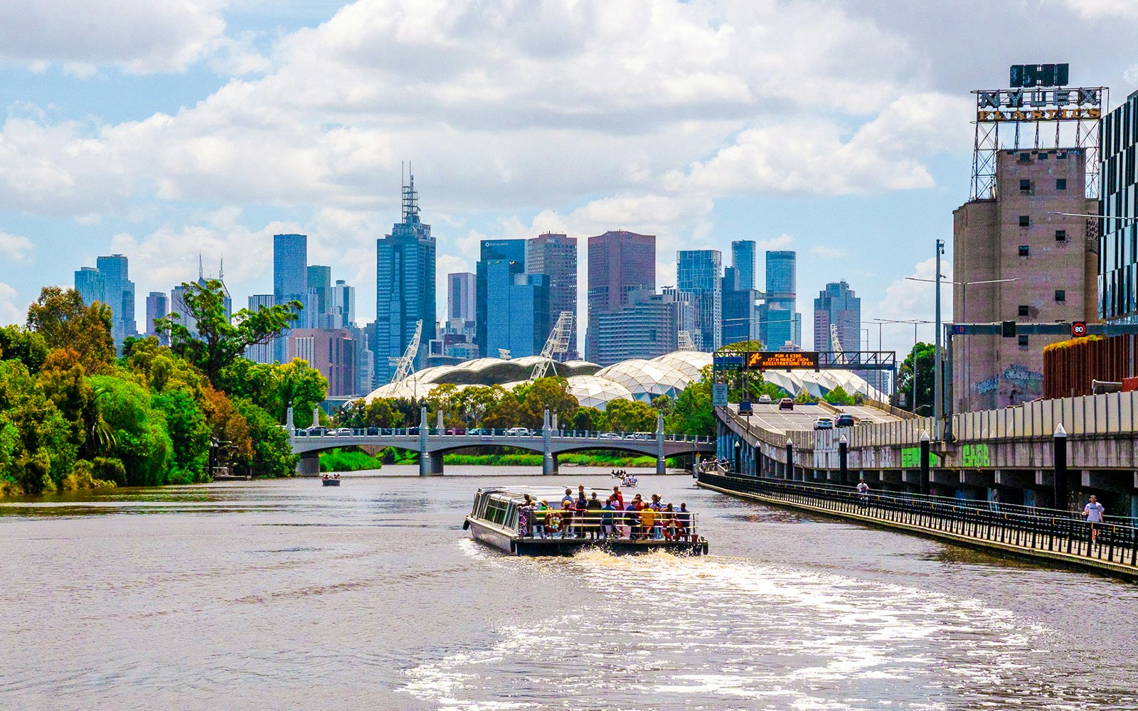 Cruise boat on Yarra River with Melbourne skyline in the background.
