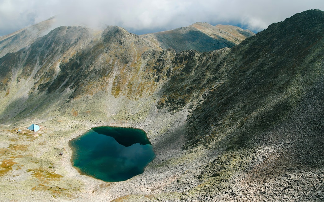 Glacial lake surrounded by rocky mountains on the route to Musala Peak, Bulgaria.