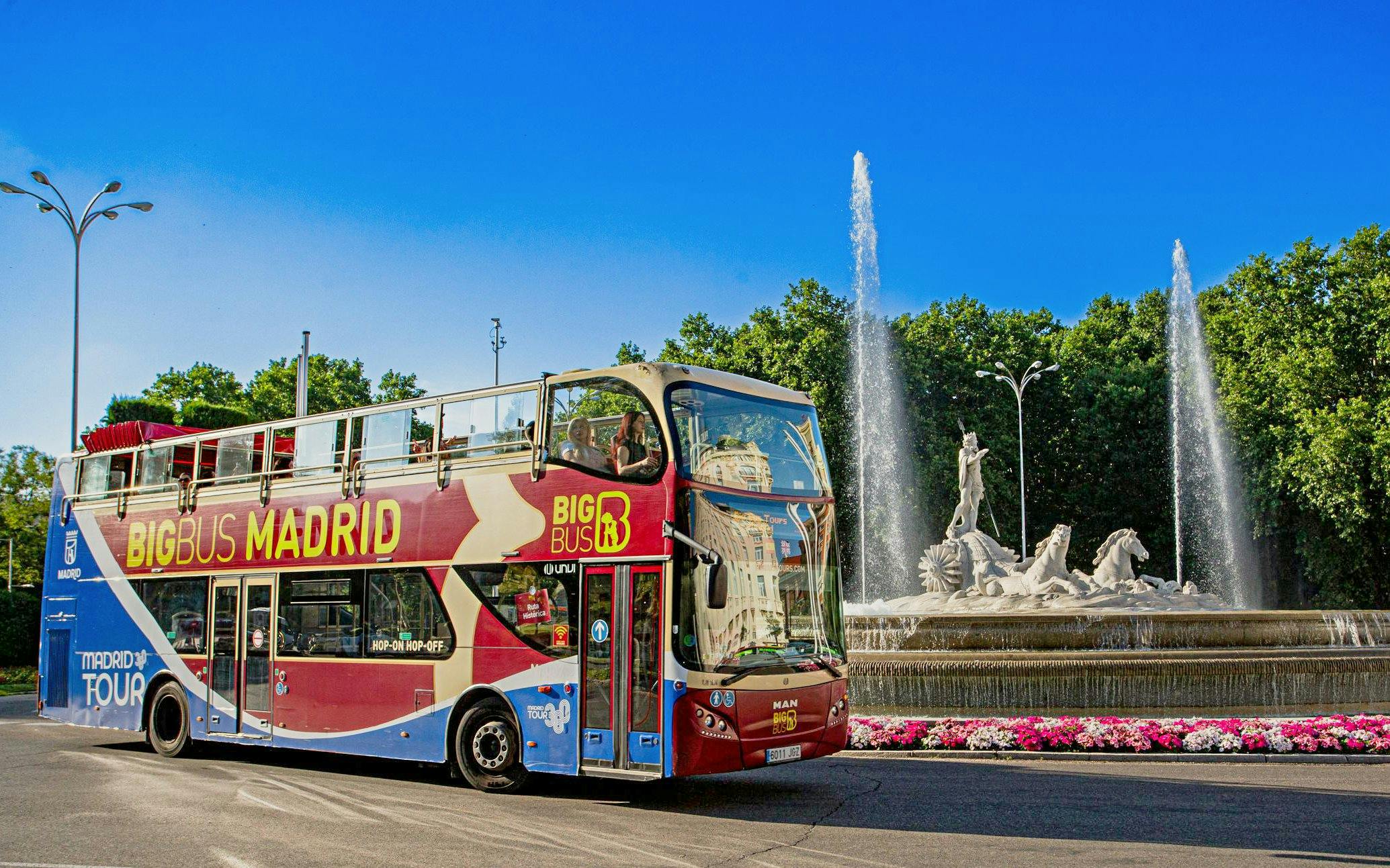 Big Bus Madrid driving past the Fountain of Neptune in Madrid, Spain.