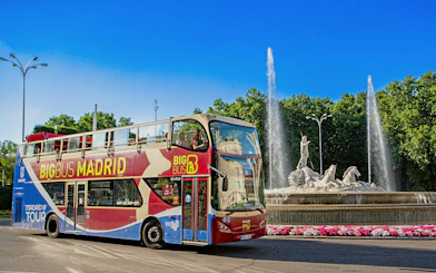 Big Bus Madrid driving past the Fountain of Neptune in Madrid, Spain.
