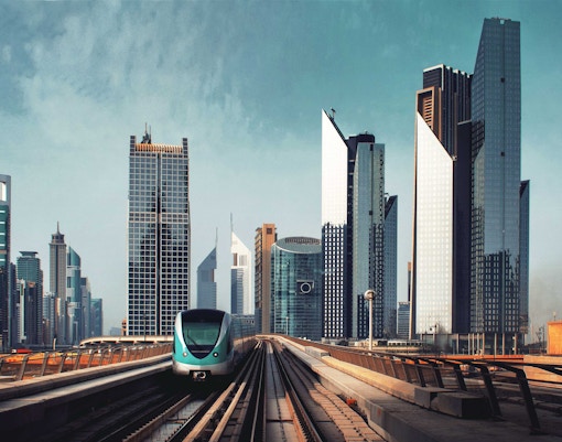 Dubai Metro train traveling through the city with skyscrapers in the background