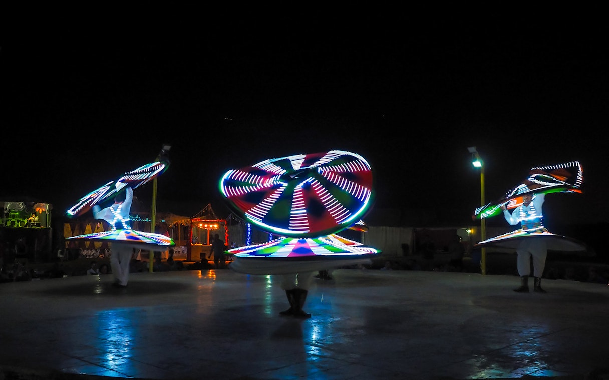 Tanoura dancers performing with illuminated skirts in Dubai.