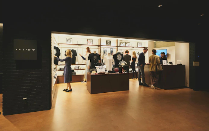 Gift shop at DRUM TAO Theater Kyoto with visitors browsing merchandise.