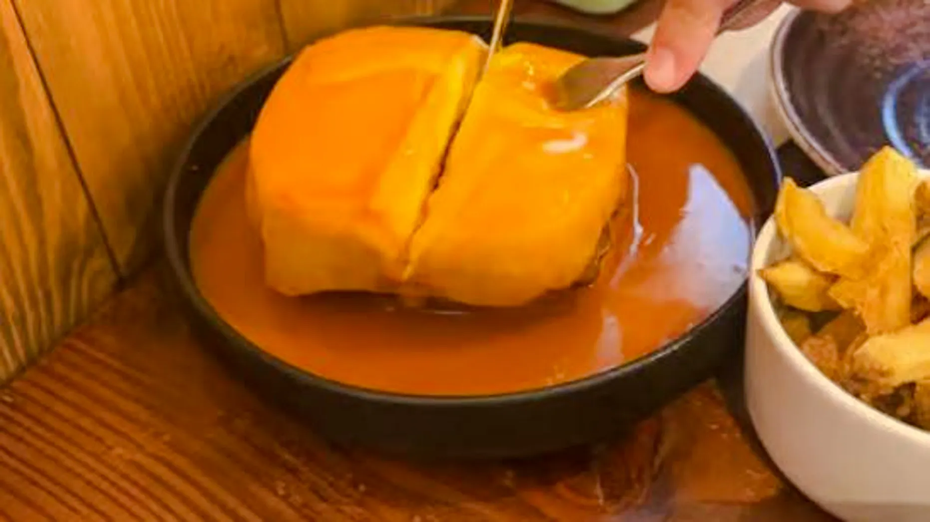 Francesinha sandwich with sauce and fries on Lisbon vegan food tour.