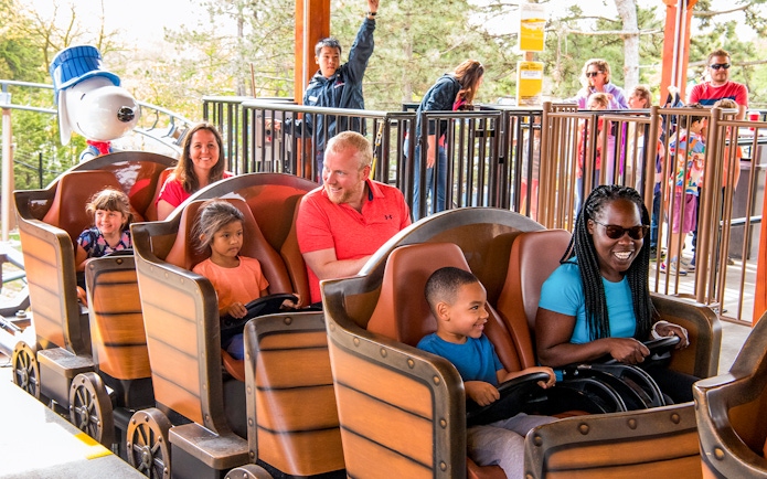 Families enjoying SNOOPY'S® Racing Railway ride at Six Flags Carowinds.
