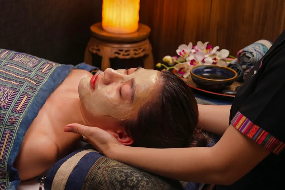 Facial treatment at Herbal Spa in Da Nang with orchids and warm lighting.