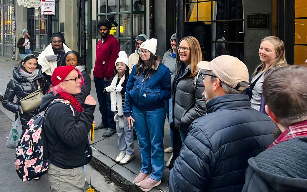 Tour group gathered for New Orleans Haunted Ghost, Voodoo & Vampire Tour outside a historical building.