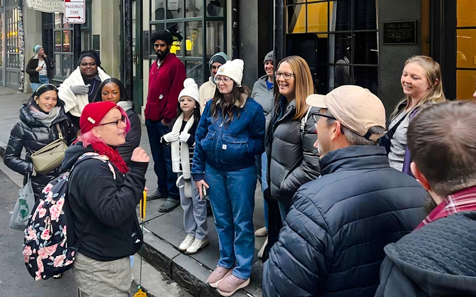 Tour group gathered for New Orleans Haunted Ghost, Voodoo & Vampire Tour outside a historical building.
