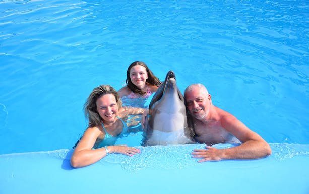 Family posing with dolphin at Egypt Dolphin World, Hurghada.