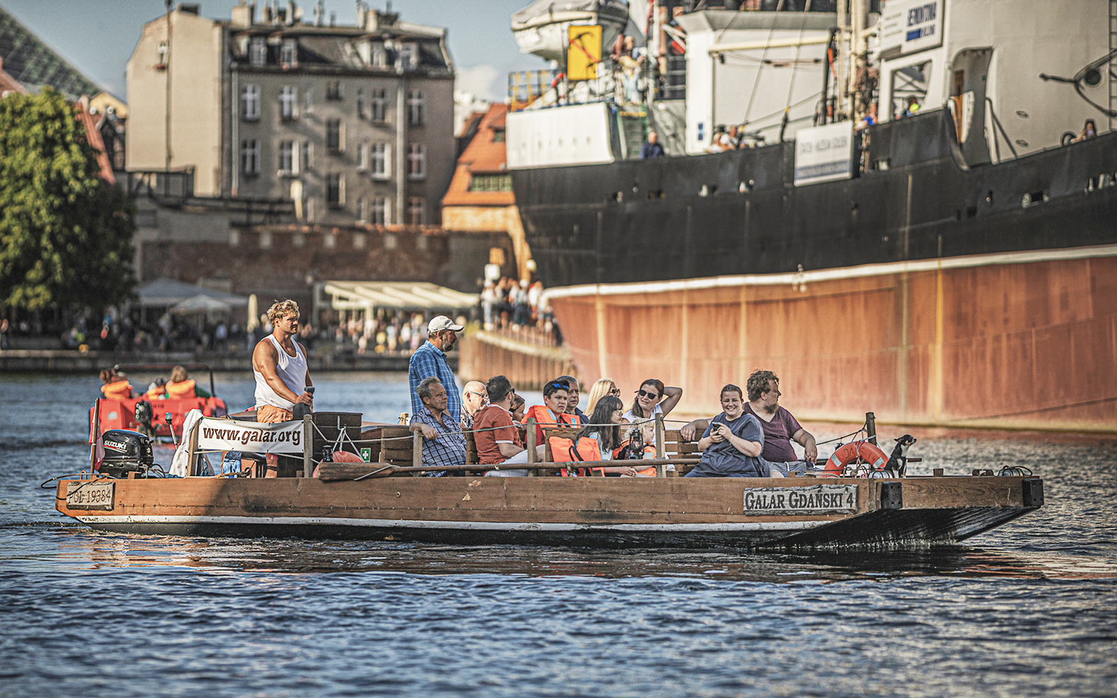 Guests enjoying a 1-hour cruise on a historical Galar boat in a scenic city harbor.