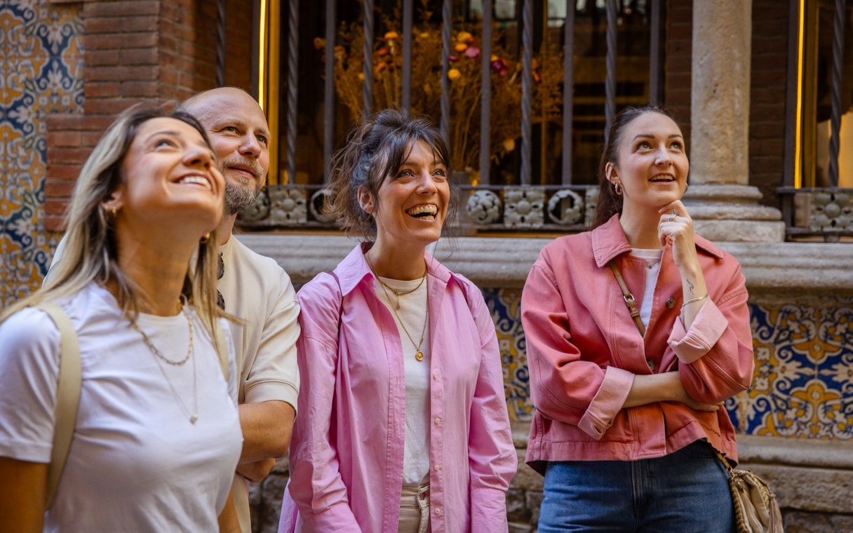 Tourists enjoying a guided walking tour in Barcelona, admiring architectural details.