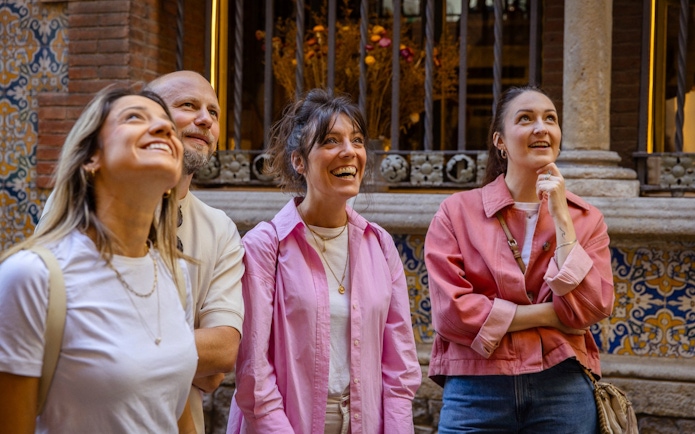 Tourists enjoying a guided walking tour in Barcelona, admiring architectural details.
