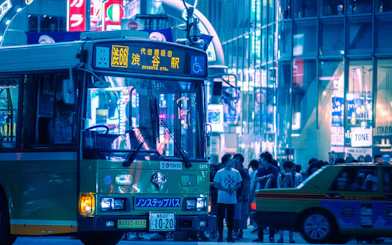 Tokyo Shibuya night scene with bus and crowd near Scramble Crossing.