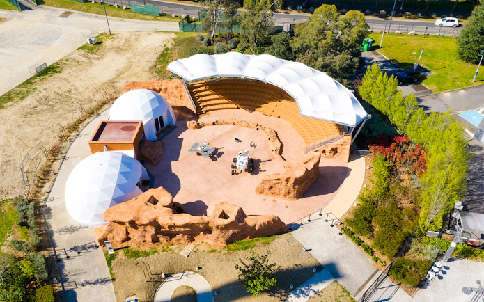 Aerial view of Mars-themed exhibit at Cité de l’Espace, France, featuring geodesic domes and amphitheater.