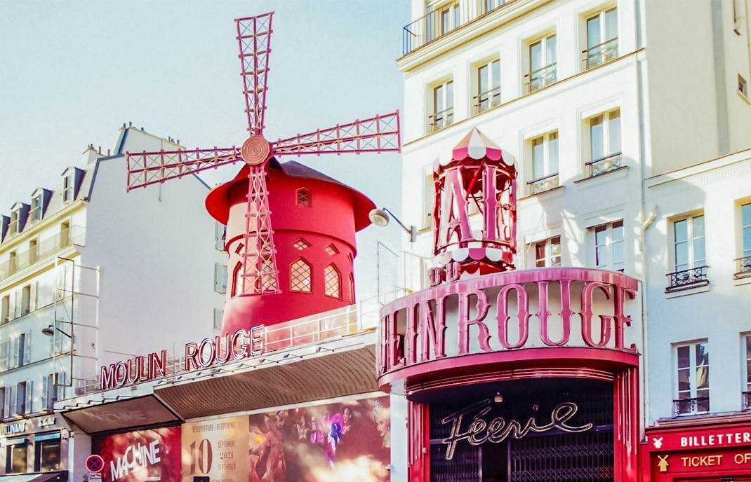 Esterno del Moulin Rouge con mulino rosso a Parigi durante il giorno.