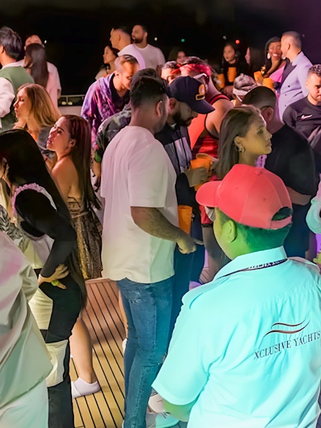 People enjoying drinks at an open bar on a party yacht in Dubai.