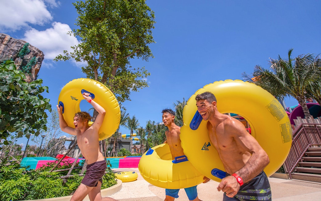 People carrying inflatable tubes to water slides at Andamanda Phuket.