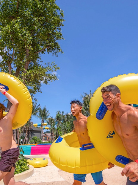 People carrying inflatable tubes to water slides at Andamanda Phuket.