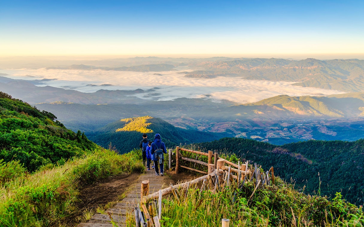 Hikers on a wooden trail with mountain views at Doi Inthanon, Chiangmai, Thailand.