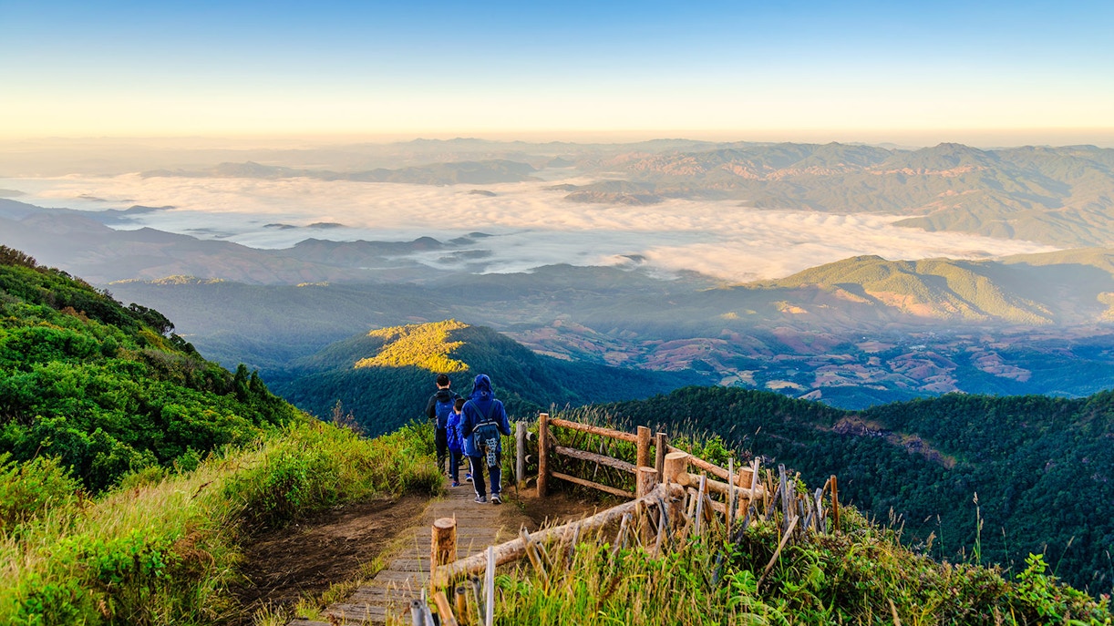 Hikers on a wooden trail with mountain views at Doi Inthanon, Chiangmai, Thailand.