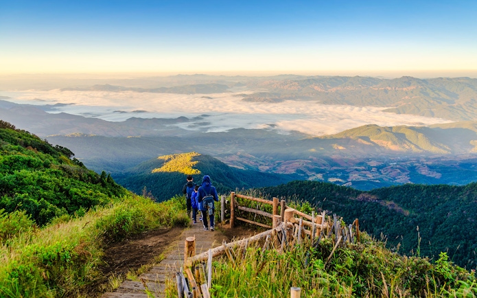 Hikers on a wooden trail with mountain views at Doi Inthanon, Chiangmai, Thailand.