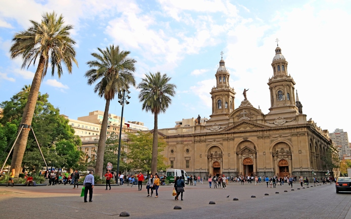Plaza de Armas Square in Santiago with people walking near the Metropolitan Cathedral.