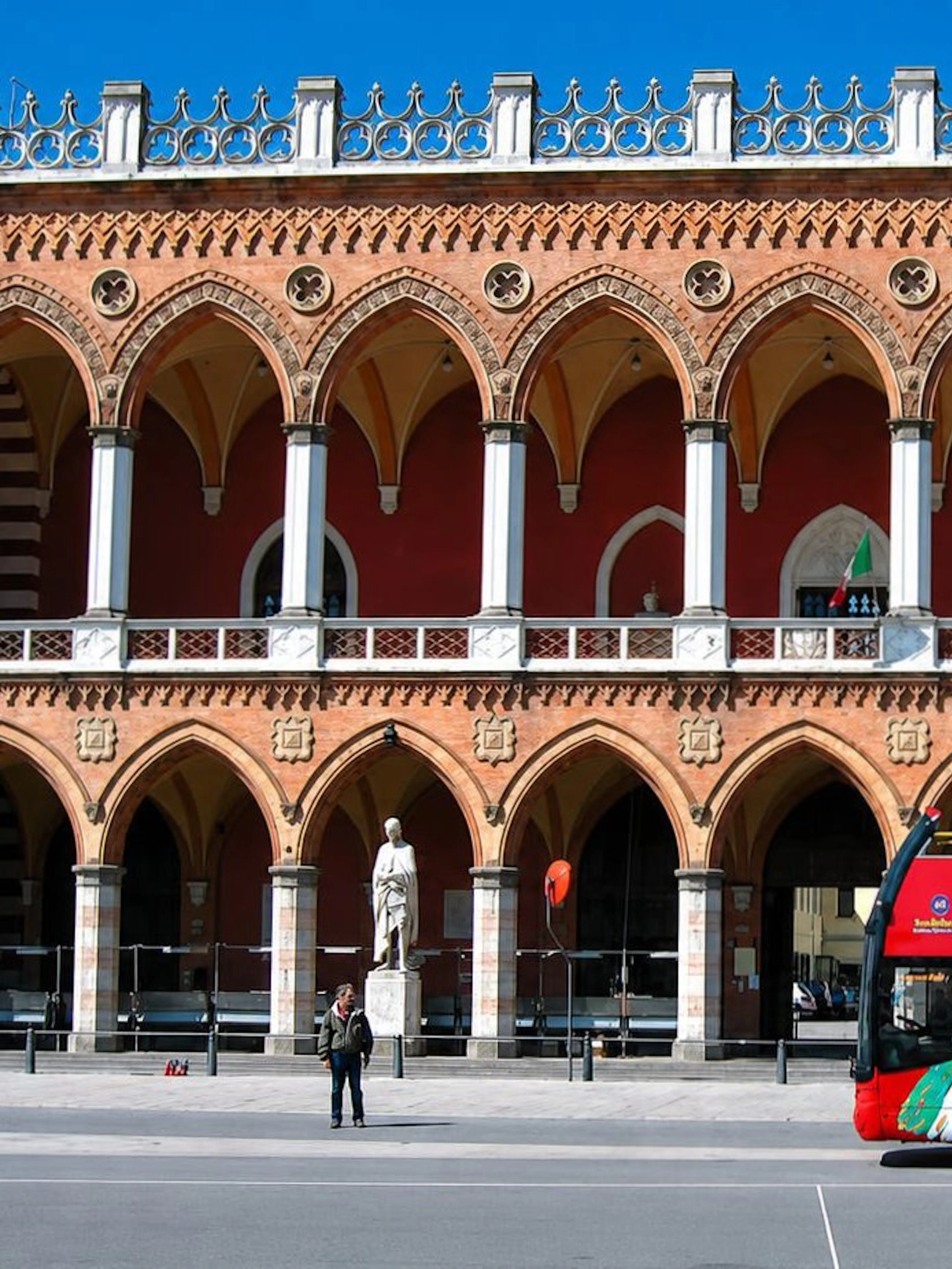 City Sightseeing bus in front of historic building in Padua, Italy.