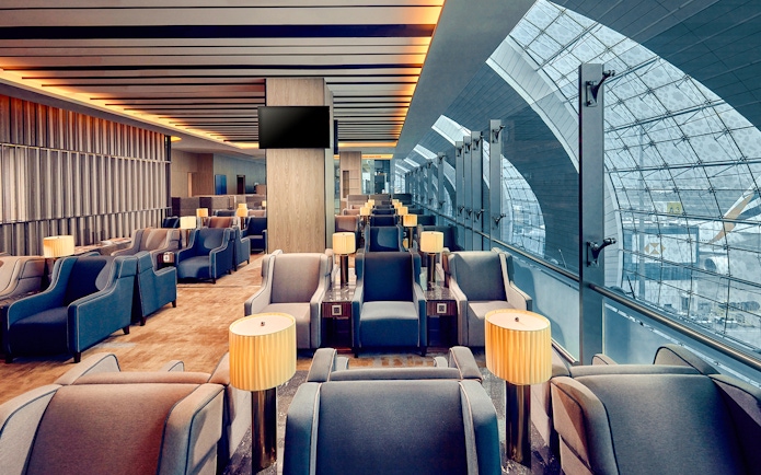 Plaza Premium Lounge seating area at Dubai International Airport with large windows.