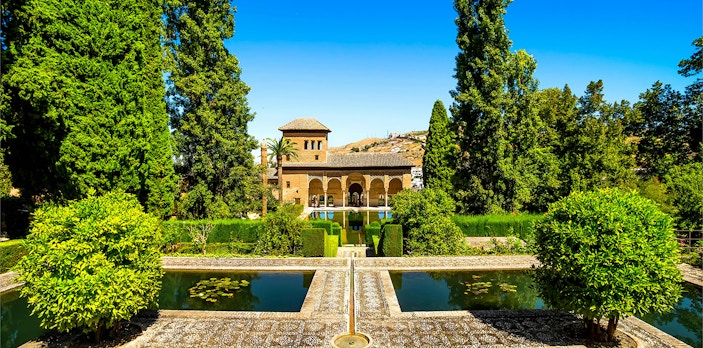 Partal Palace at Alhambra with reflecting pools and lush gardens in Granada, Spain.