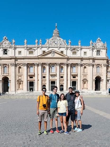 Visitors in front of St. Peter’s Basilica during a guided tour in Vatican City.