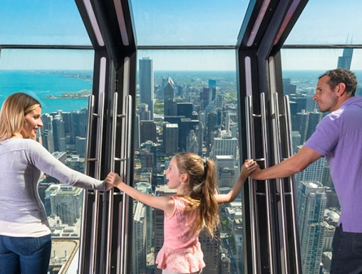 Family enjoying the view from 360 Chicago observation deck.