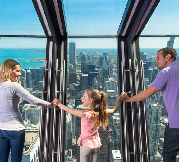 Family enjoying the view from 360 Chicago observation deck.
