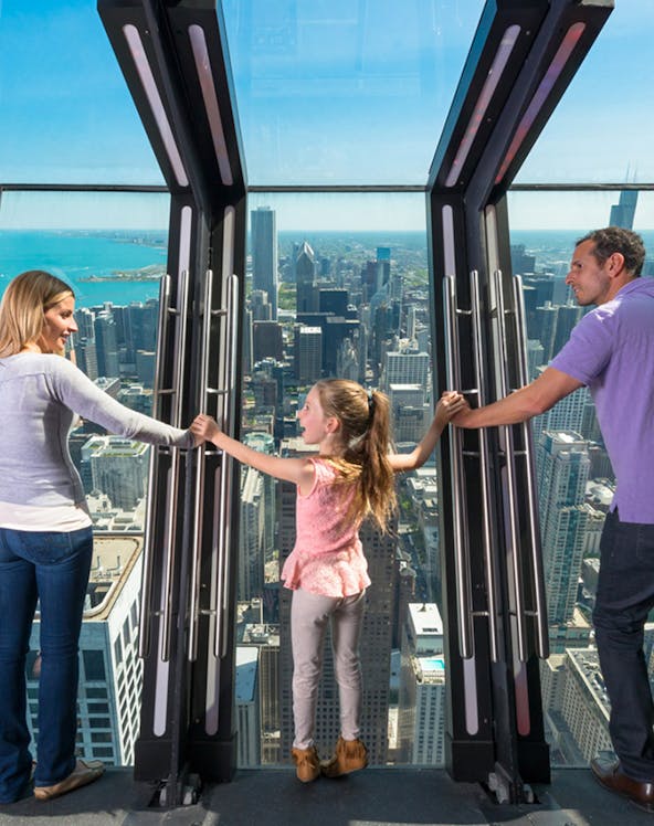 Family enjoying the view from 360 Chicago observation deck.