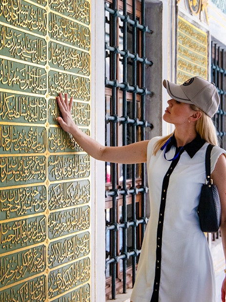 Visitor admiring Arabic inscriptions at Topkapi Palace, Istanbul.