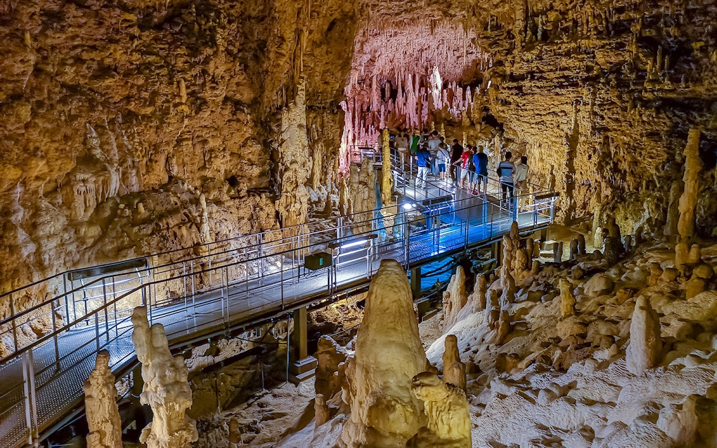 Visitors exploring stalactites and stalagmites in Gyokusendo Cave, Okinawa World.