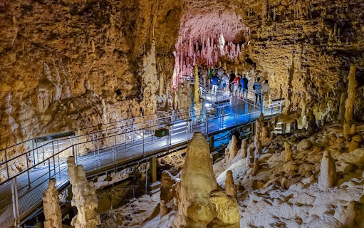Visitors exploring stalactites and stalagmites in Gyokusendo Cave, Okinawa World.