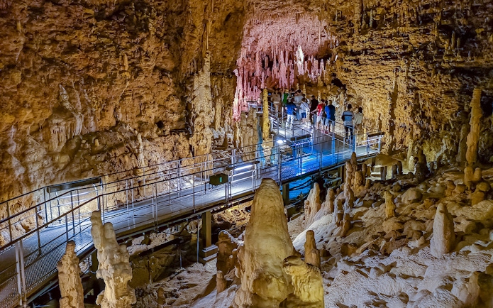 Visitors exploring stalactites and stalagmites in Gyokusendo Cave, Okinawa World.