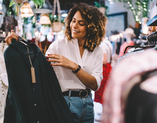 Genting Premium Outlets shopping area with visitors exploring stores and scenic mountain backdrop.