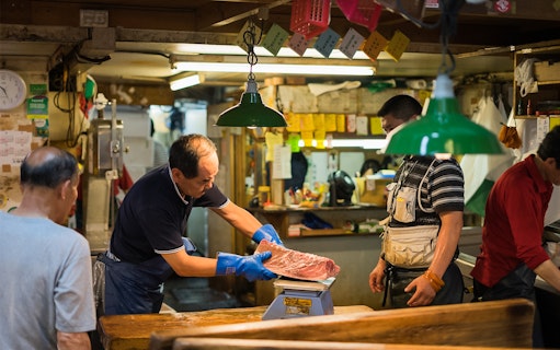 Fish vendor weighing tuna at Tsukiji Outer Market, Tokyo.