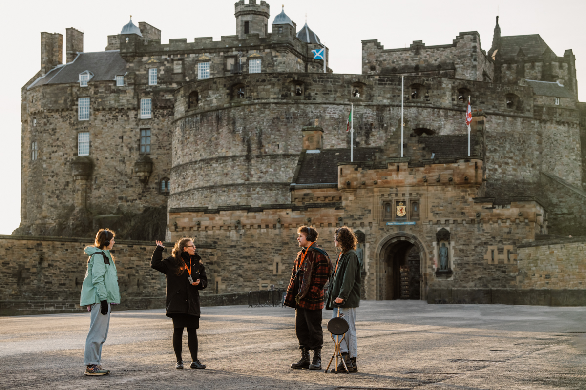 Tour guide explaining Edinburgh Castle history to visitors on the Royal Mile tour.