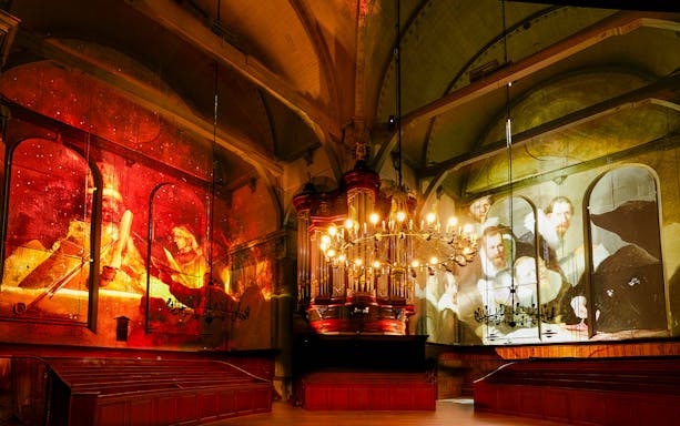 Van Gogh and Rembrandt art projected in a sound and light show inside a historic building.