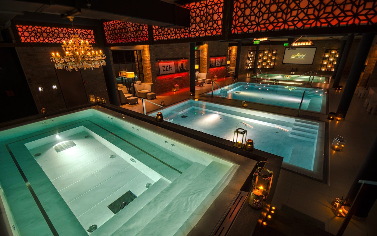 Luxurious indoor pools at Mandala Day Spa with ambient lighting and elegant decor.