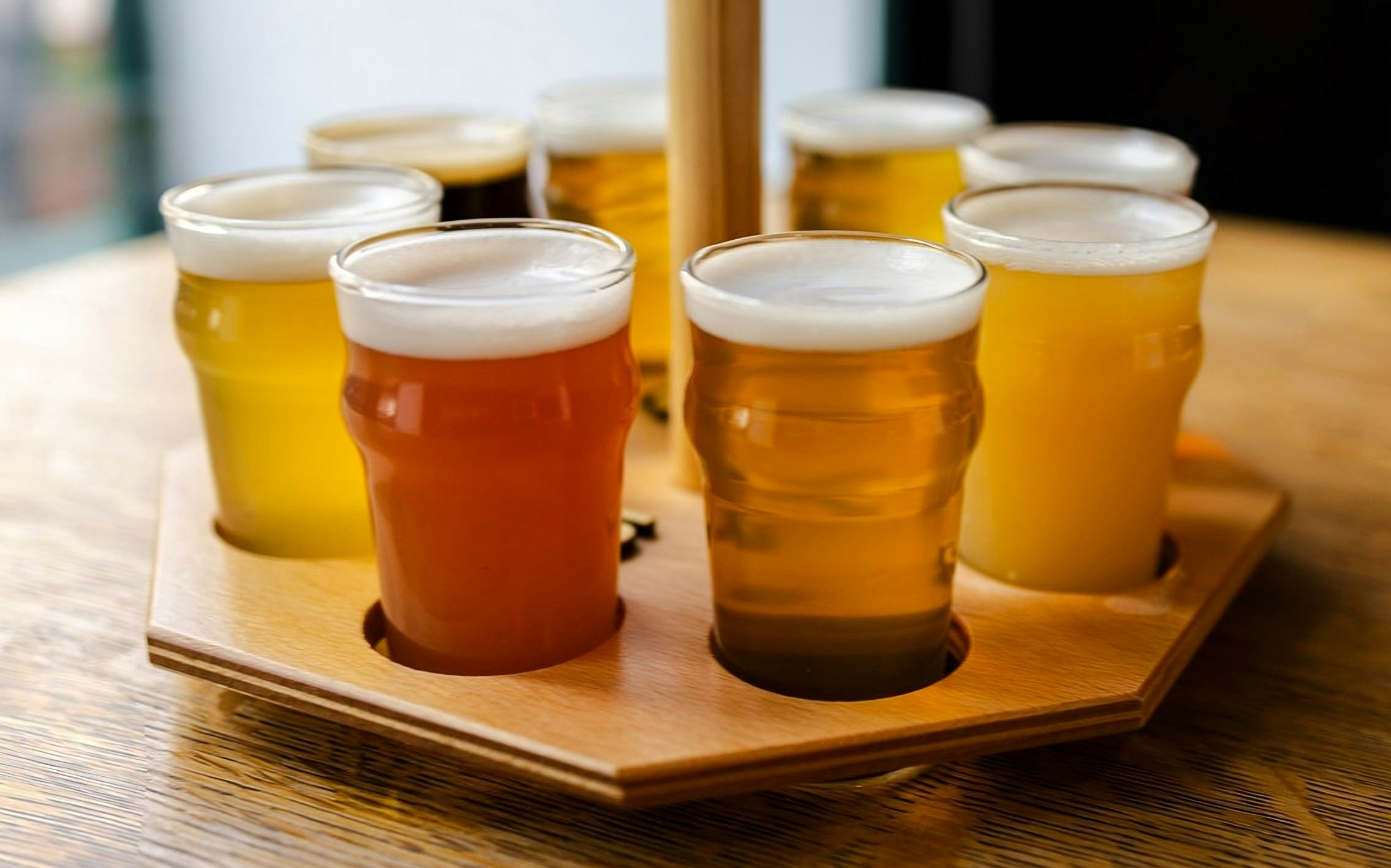 Assorted beers on a wooden tray during a tasting session in Prague brewery tour.