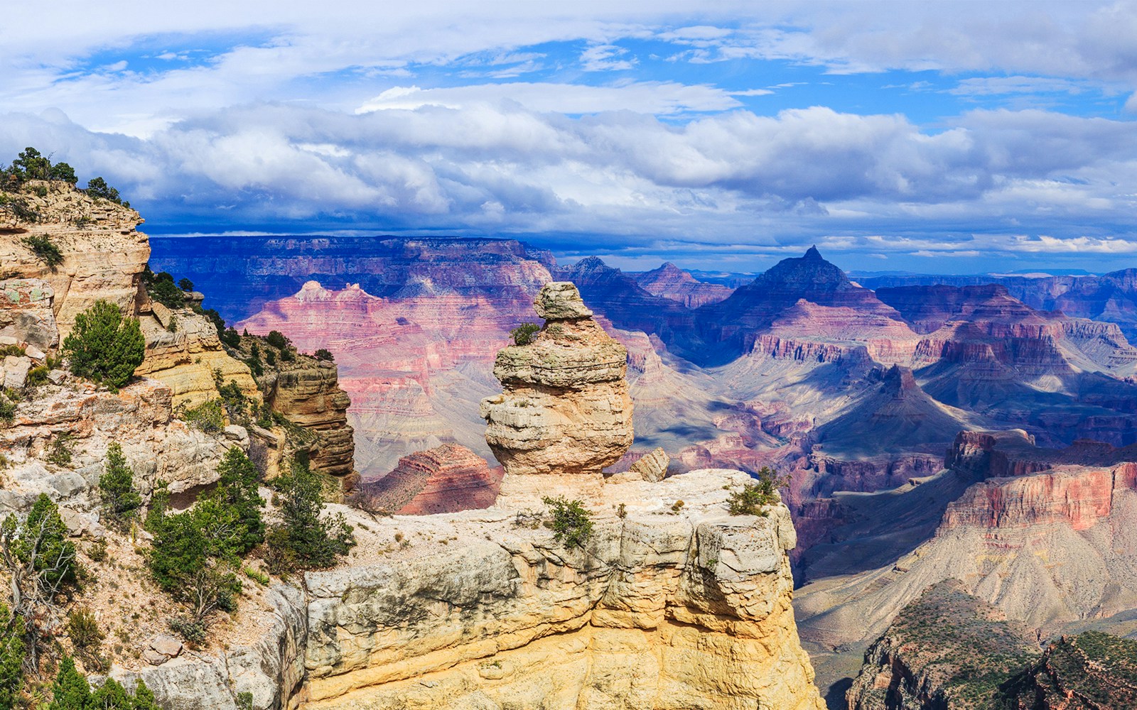 Duck Rock formation at Grand Canyon with layered cliffs and distant peaks.