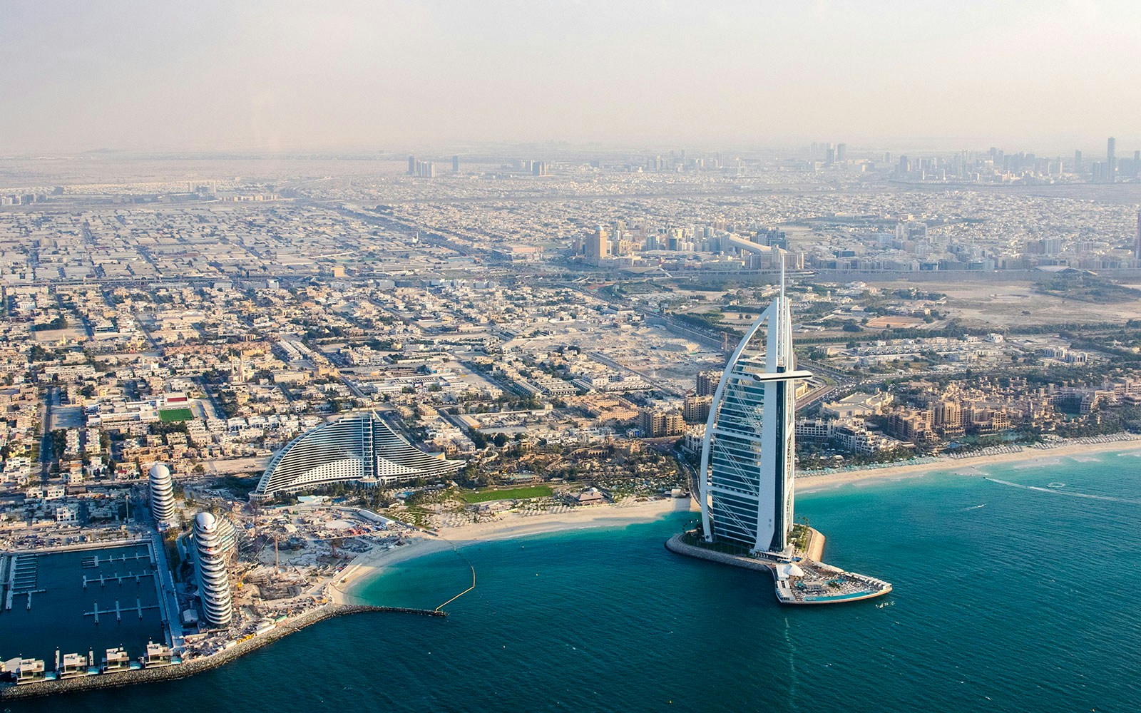 Aerial view of Burj Al Arab and surrounding Dubai coastline.
