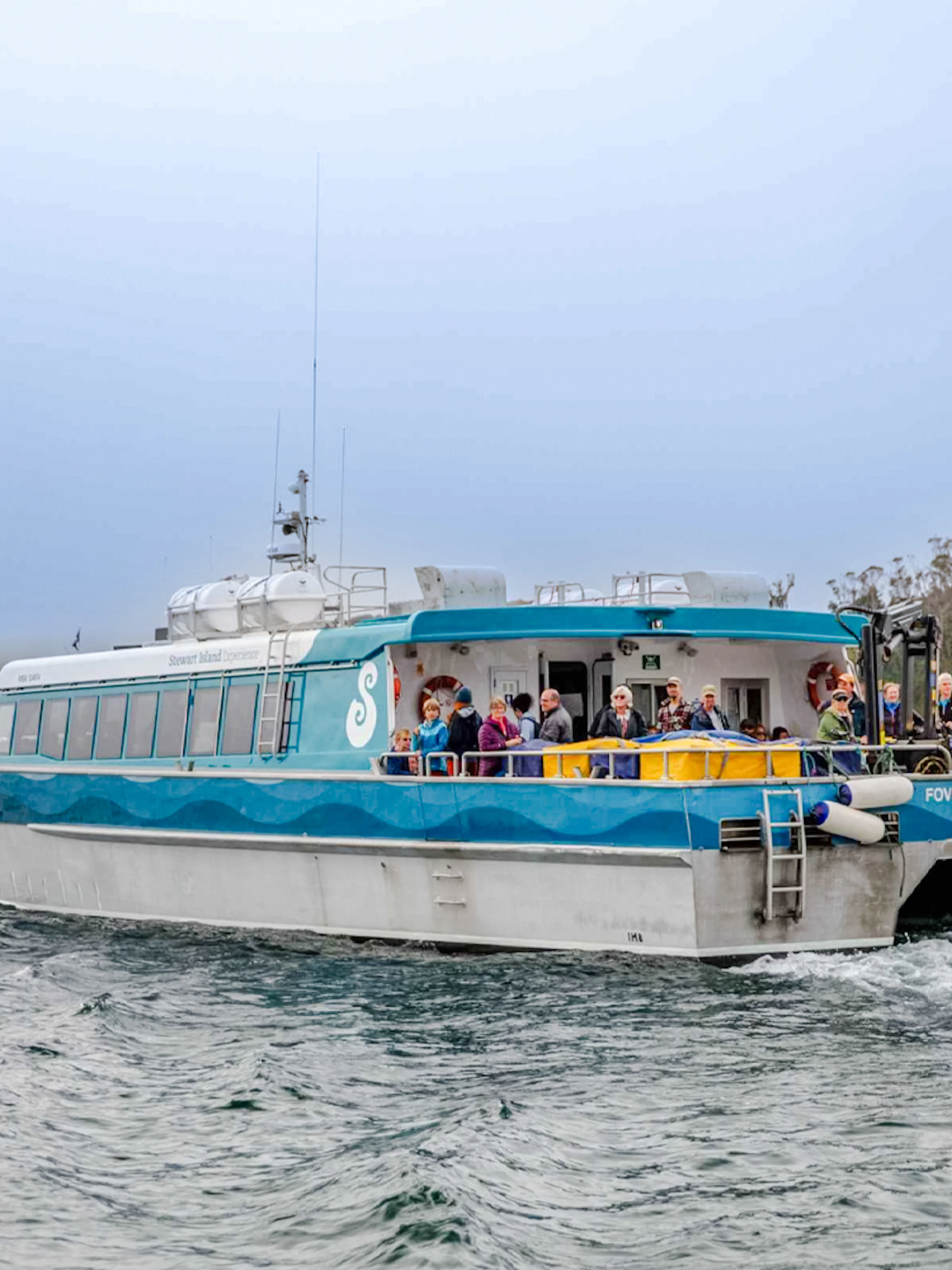 Tourists on the deck of the Stewart Island Ferry in New Zealand waters.