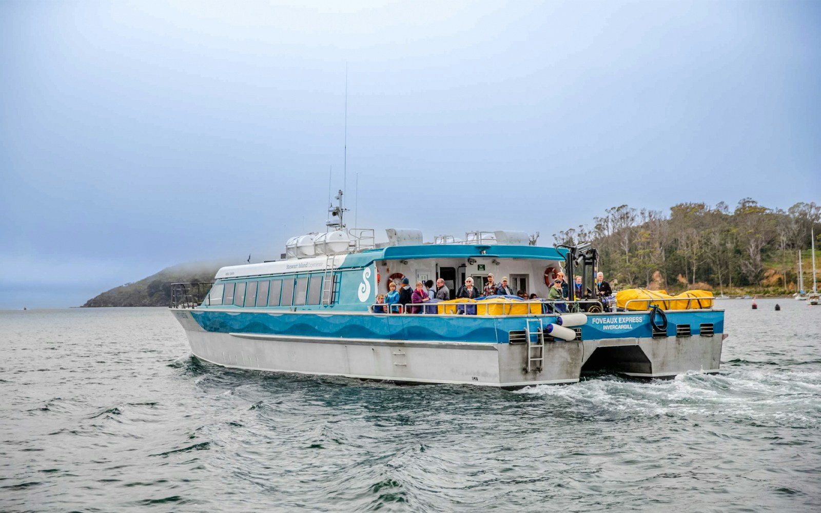 Tourists on the deck of the Stewart Island Ferry in New Zealand waters.