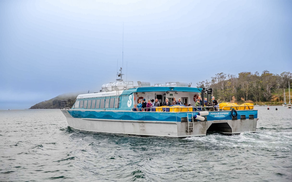 Tourists on the deck of the Stewart Island Ferry in New Zealand waters.