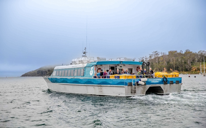 Tourists on the deck of the Stewart Island Ferry in New Zealand waters.