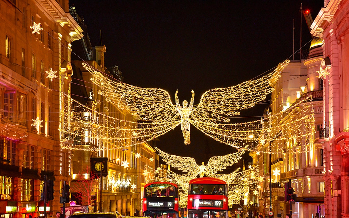 London Christmas lights on Regent Street with festive decorations and bustling holiday shoppers.